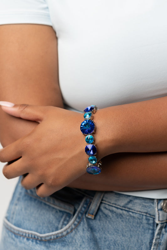 Refreshing Radiance - Blue Bracelet - Paparazzi Accessories - Pressed in silver-pronged frames, vibrant blue gems in varying sizes and shades alternate along stretchy bands around the wrist, creating a colorful pop of color. The larger blue gems feature a stellar UV shimmer for additional eye catching shimmer. Sold as one individual bracelet.