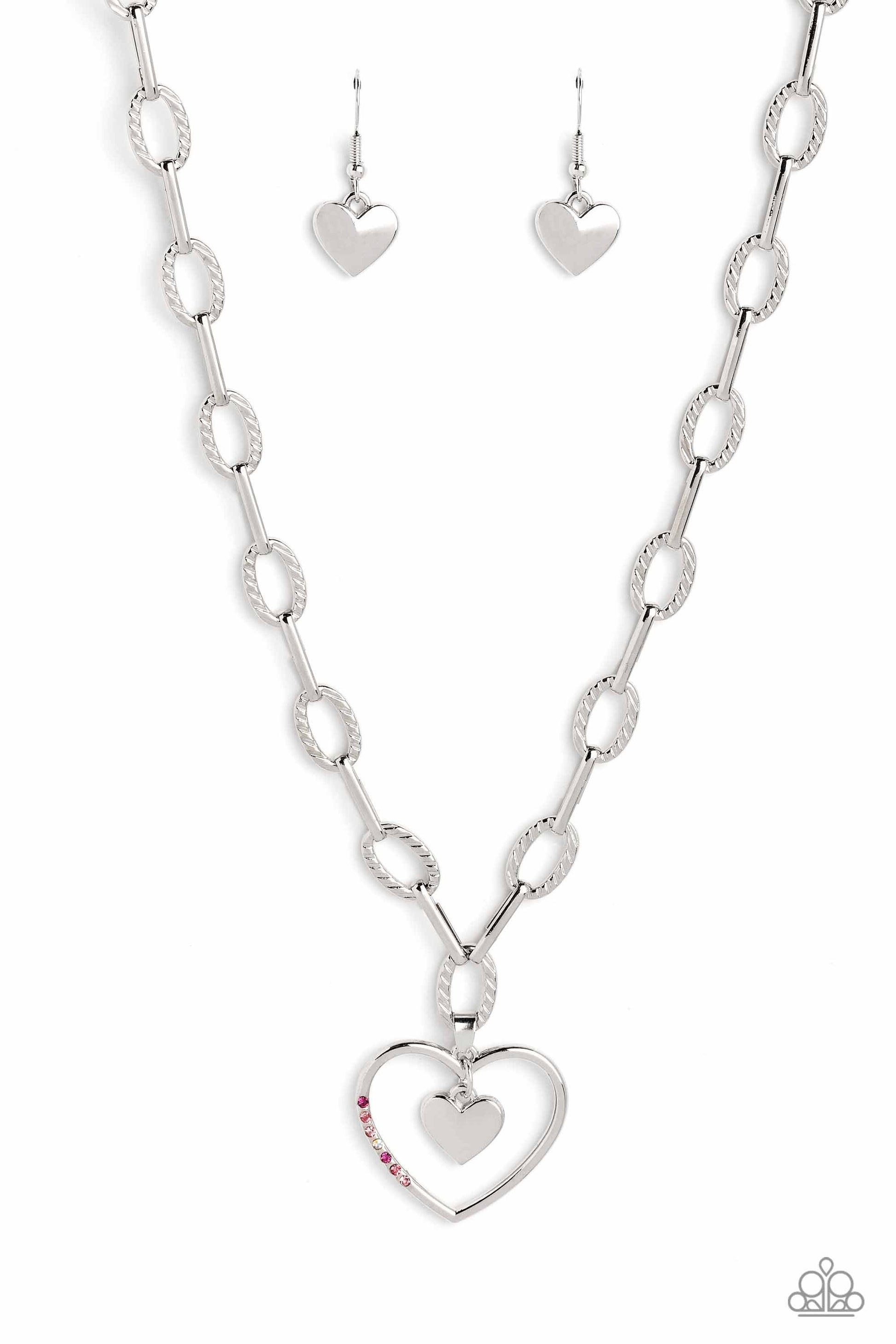 Refulgent Romance - Pink and Silver Heart Necklace - Textured ovals and elongated silver links lead the eye down to an oversized, airy, silver heart frame. Encrusted along one of the curves of the silver heart, dainty rhinestones in shades of pink, including fuchsia, rose, light rose, and iridescence, glimmer for a subtle pop of color. Dangling inside the oversized heart frame, a silver heart pendant swings for a romantic finish.