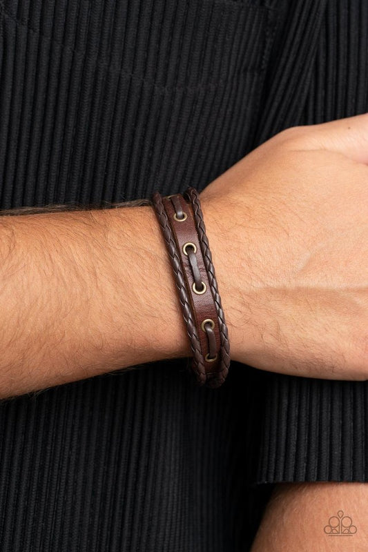 Road Cruise - Brass Brown Urban Bracelet - Paparazzi Accessories - Infused with brown leather laces, a rustic piece of brown leather joins a pair of braided leather cords around the wrist, stacking into an adventurous centerpiece. Features an adjustable snap closure.