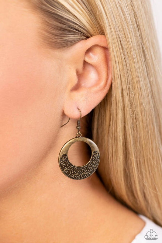 Secret Vineyards - Brass Earrings - Paparazzi Accessories - Infused with brass studs, frilly vine-like filigree whirls out across the bottom of a brass hoop for a seasonal shimmer. Earrings attaches to a standard fishhook fitting. Sold as one pair of earrings.