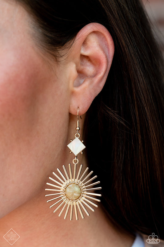 Seize the Sunburst - Gold Earrings - Paparazzi Accessories - A white shell is tilted on its side and bordered by gold studs, giving way to a large gold sunburst dotted with a multicolored stone center; resulting in a whimsically radiant lure. Earring attaches to a standard fishhook fitting.