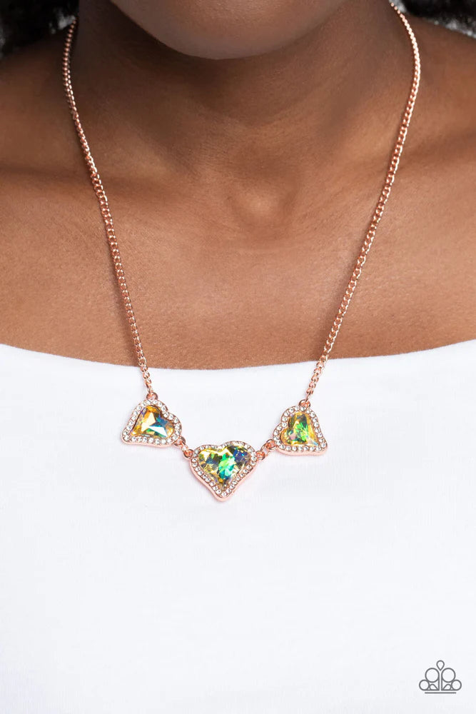 State Of The HEART - Copper Iridescent Necklace - Paparazzi Accessories - Nestled in white rhinestone frames, a trio of glittery iridescent yellow heart-shaped gems delicately links and dangles down the neckline for a dash of swoon-worthy shimmer on a shiny copper chain. Features an adjustable clasp closure. Due to its prismatic palette, color may vary. Sold as one individual necklace.