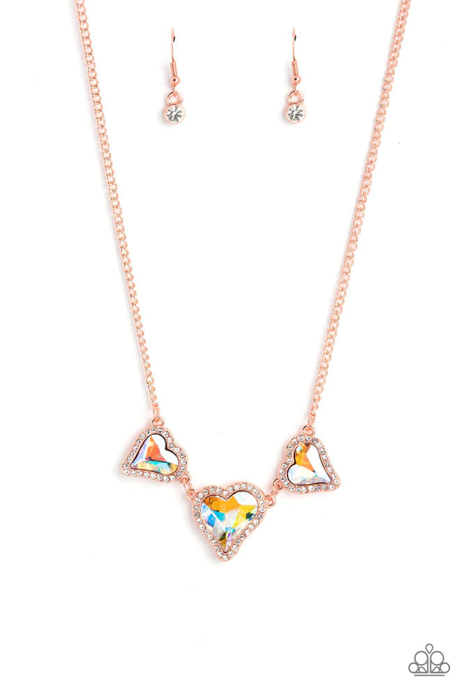 State Of The HEART - Copper Iridescent Necklace - Paparazzi Accessories - Nestled in white rhinestone frames, a trio of glittery iridescent yellow heart-shaped gems delicately links and dangles down the neckline for a dash of swoon-worthy shimmer on a shiny copper chain. Features an adjustable clasp closure. Due to its prismatic palette, color may vary. Sold as one individual necklace.