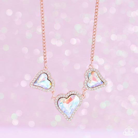 State Of The HEART - Copper Iridescent Necklace - Paparazzi Accessories - Nestled in white rhinestone frames, a trio of glittery iridescent yellow heart-shaped gems delicately links and dangles down the neckline for a dash of swoon-worthy shimmer on a shiny copper chain.  Features an adjustable clasp closure.  Due to its prismatic palette, color may vary. Sold as one individual necklace.