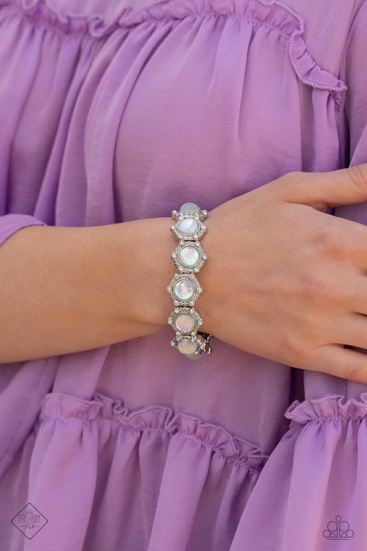 Summer Stupor - Green and Silver Bracelet - Paparazzi Accessories - Silver frames, rippling in intricate texture and featuring a subtle hexagonal shape, are dusted in dainty white rhinestones. Featuring an opalescent finish, glassy green beaded centers shimmer around the wrist for a dreamy design infused on an elastic stretchy band. Sold as one individual bracelet.