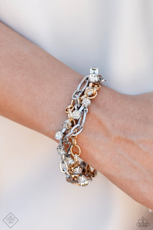 Two-Tone Taste - Multi Metal Bracelet - Paparazzi Accessories - Mismatched strands of glistening gold and silver oval links are intertwined with a row of sparkling, square-cut, white rhinestones encased in sleek silver fittings, resulting in a twisted collision of grit and glamour around the wrist.