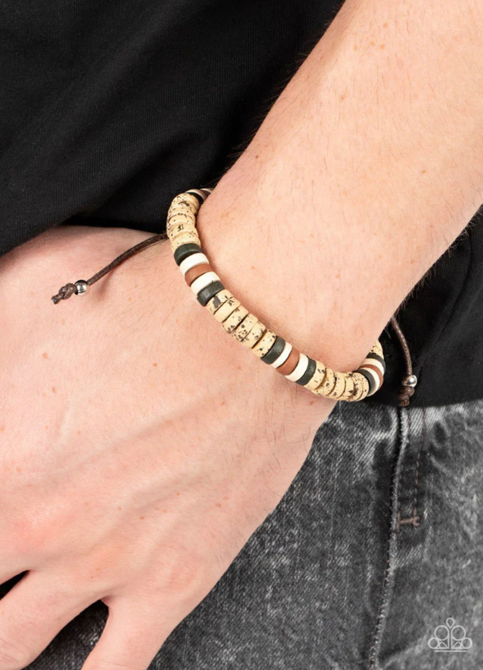 Wild Wanderer - Brown Urban Bracelet - Paparazzi Accessories - An earthy collection of green, white, brown, and speckled wooden discs are threaded along a brown cord around the wrist for an adventurous pop of color. Features an adjustable sliding knot closure. Sold as one individual bracelet.