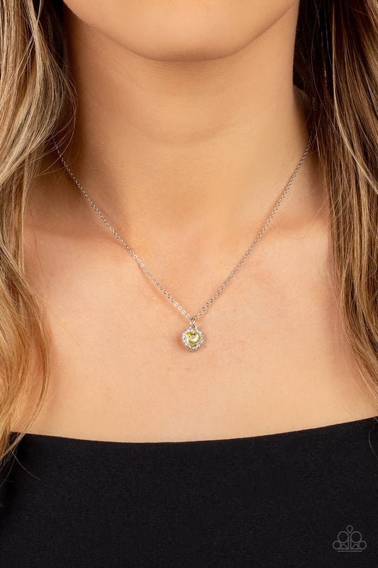 A Little Lovestruck - Yellow and Silver Heart Rhinestone Necklace - Paparazzi Accessories - Dainty yellow rhinestone heart sparkles along a dainty silver chain below the collar for a flirtatious fashion.