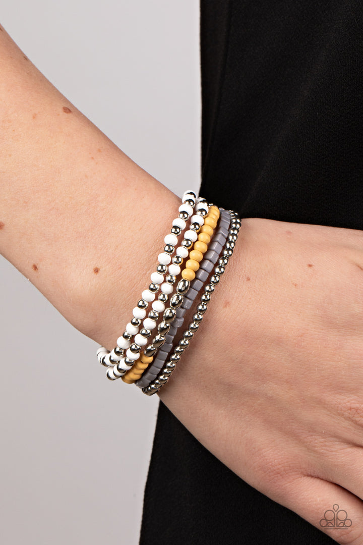 Adventure Is Calling - Fashion Bracelet - Paparazzi Accessories - Featuring the neutral shades of white, Northern Droplet, silver, and Daffodil, an adventurous assortment of round and cube beads are threaded along stretchy bands around the wrist for a colorfully layered look. Sold as one set of four bracelets.