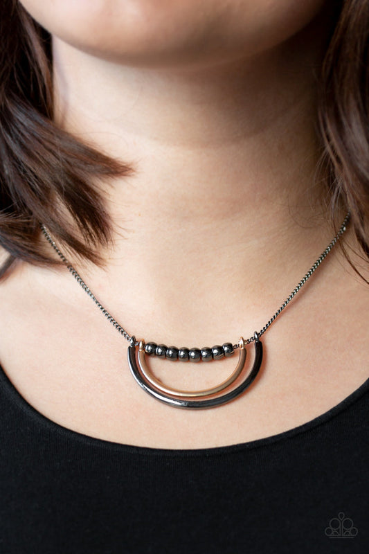 Artificial Arches - Black - Gunmetal and Gold Fashion Necklace - Paparazzi Accessories - A strand of shiny gunmetal beads give way to bowing gold and gunmetal frames, creating an edgy pendant below the collar. Features an adjustable clasp closure.