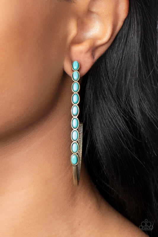 Artisan Soul - Brass and Turquoise Earrings - Paparazzi Accessories - Oval turquoise stones are pressed into the front of a dramatically oversized brass j-shaped hoop, adding an artisan twist to the trendsetting design. Earring attaches to a standard post fitting. Hoop measures approximately 2" in diameter. Sold as one pair of hoop earrings.