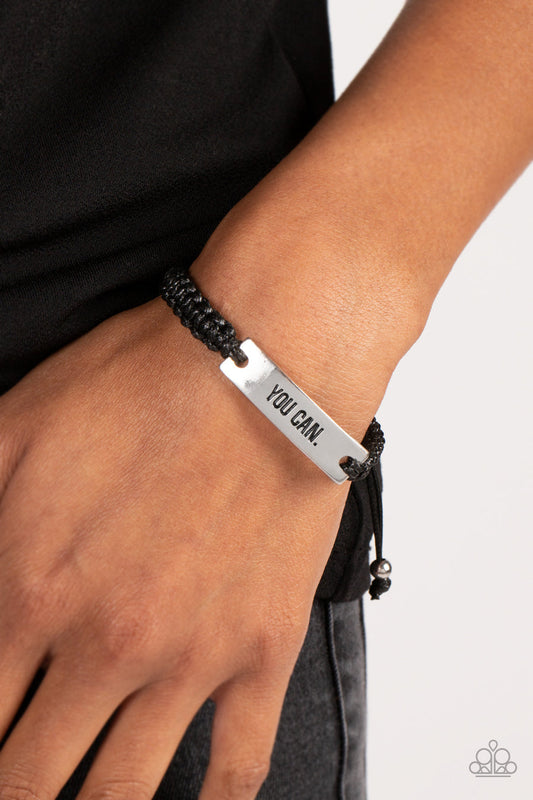 Beyond Belief - Black and Silver Urban Bracelet - Paprazzi Accessories - Thick black cording is woven together, wrapping around the wrist and connecting to a rectangular plate of silver. The phrase "You Can." is stamped into the center of the silver plate, adding a bold message of encouragement to the casual design.