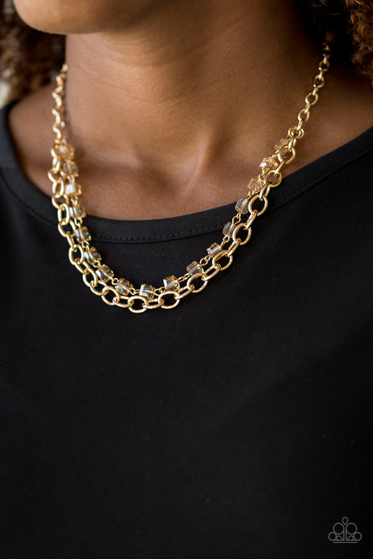 Block Party Princess - Gold Fashion Necklace - Paparazzi Accessories - A strand of golden crystal-like cube beading joins a classic strand of gold chain below the collar, creating refined layers.