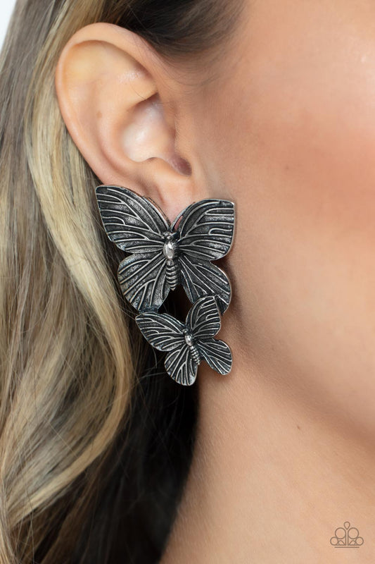 Blushing Butterflies - Silver Fashion Earrings - Paparazzi Accessories - Veined with lifelike textures, a pair of rustic silver butterflies flutters from the ear for a whimsical fashion. Earring attaches to a standard post fitting fashion earrings. 