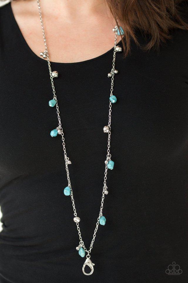 Both Feet On The Ground - Blue Turquoise and Silver Lanyard - Paparazzi Accessories - Refreshing turquoise pebbles and an array of glistening silver beads trickle along a lengthened silver chain for a seasonal look. A lobster clasp hangs from the bottom of the design to allow a name badge or other item to be attached.