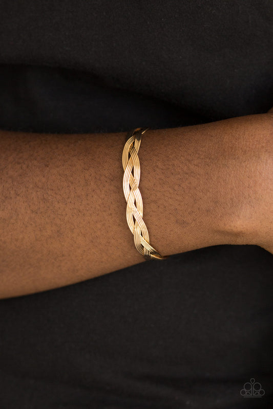 Business As Usual - Gold Cuff Bracelet - Paparazzi Accessories - Glistening gold wires braid across the wrist, coalescing into a dainty cuff. Sold as one individual bracelet.