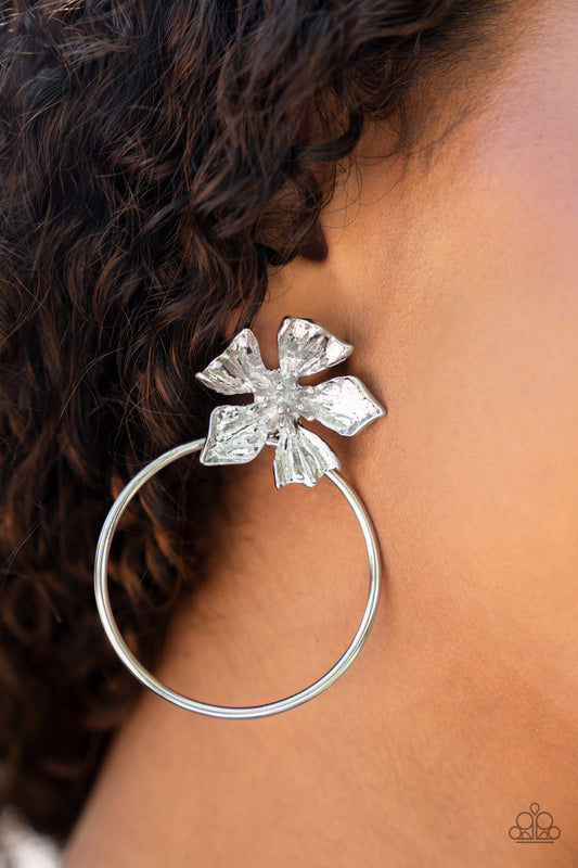 Buttercup Bliss - Silver Floral Fashion Earrings - Paparazzi Accessories - Featuring lifelike textures, a shimmery silver buttercup blooms atop an oversized silver hoop for a whimsical allure. Earring attaches to a standard post fitting. Sold as one pair of post earrings.
