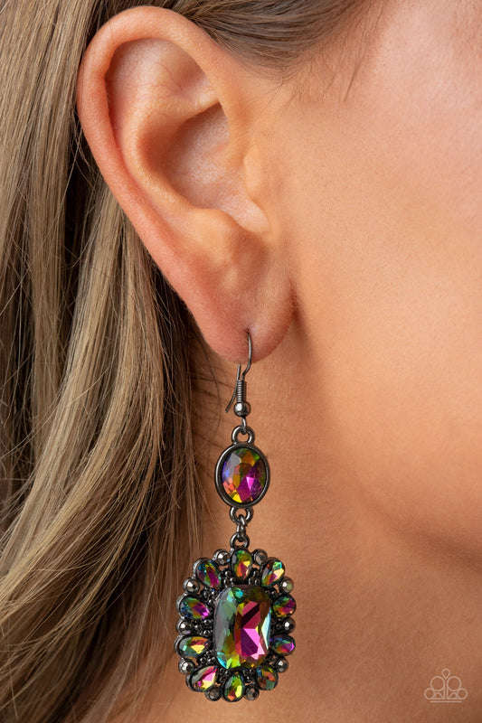 Capriciously Cosmopolitan - Multi Color - Oil Spill Earrings - Paparazzi Accessories - Dainty hematite rhinestones and teardrop oil spill gems fan out from an oversized oil spill emerald cut gem at the bottom of a solitaire oval oil spill gem, resulting in a glamorously glitzy lure. Earring attaches to a standard fishhook fitting. Sold as one pair of earrings.