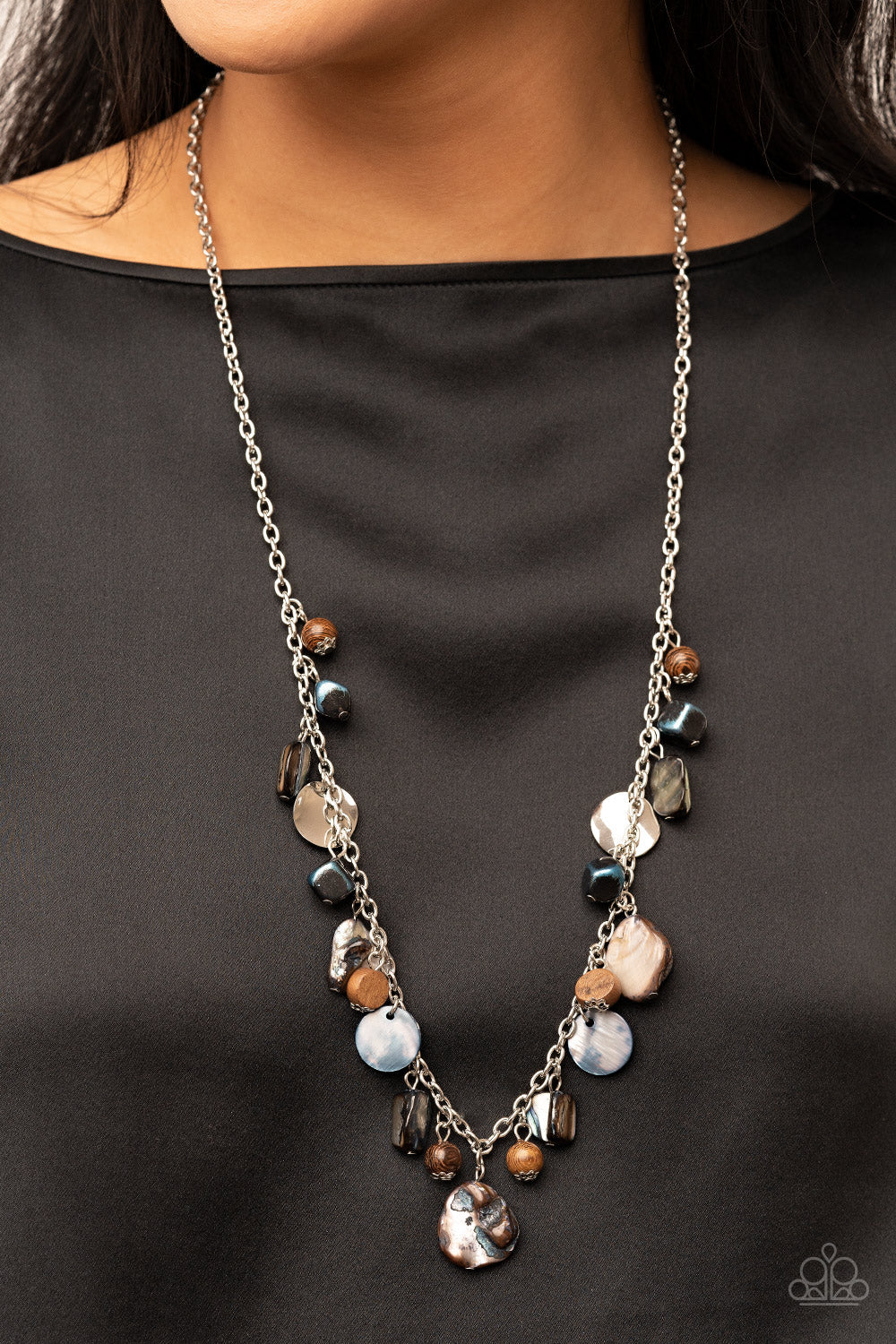 Caribbean Charisma - Blue and Silver Necklace - Paparazzi Jewelry - Bejeweled Accessories By Kristie - A mismatched collection of warped silver discs, brown wooden beads, and iridescent shell-like rock accents dances from the bottom of a classic silver chain, creating a tropical sensation across the chest. Features an adjustable clasp closure. Sold as one individual necklace.