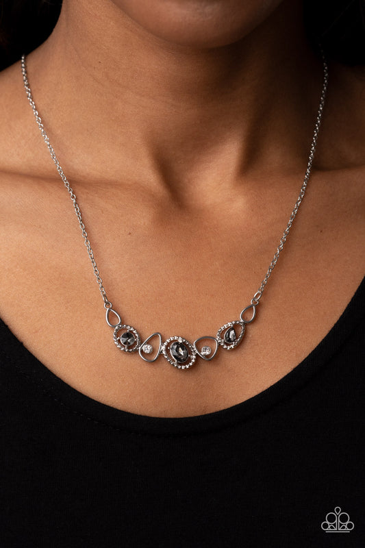 Celestial Cadence - Smoky Gem - Silver Necklace - Paparazzi Accessories - An incandescent assortment of shiny silver frames, dainty white rhinestones, and oversized smoky gems delicately coalesce into a statement-making sparkle below the collar. Features an adjustable clasp closure.