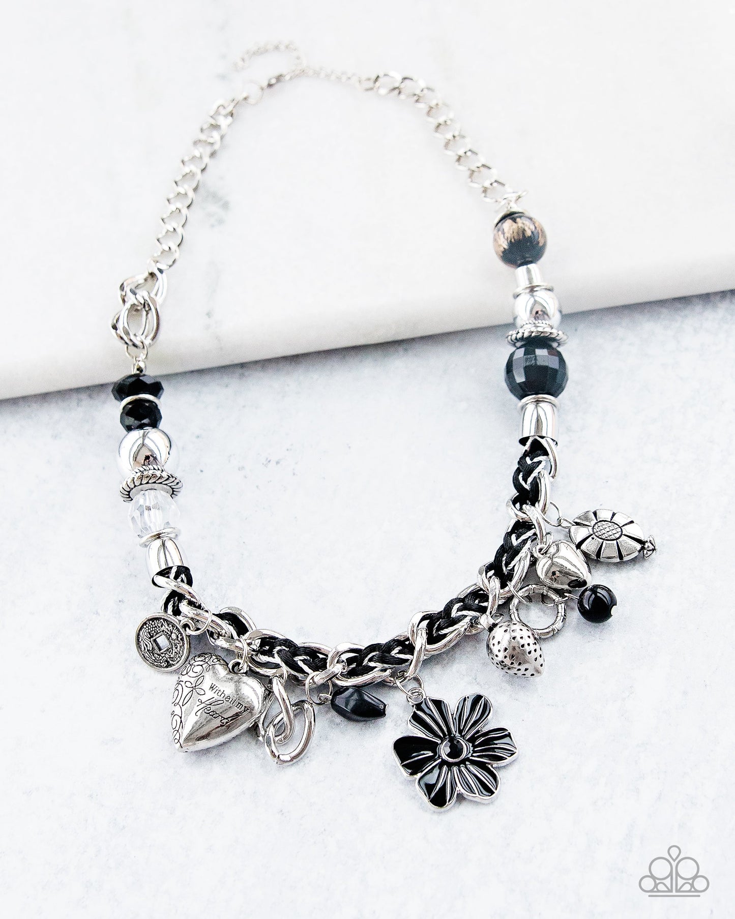 Charmed, I Am Sure - Black and Silver Necklace - Paparazzi Accessories - Black and ivory cording is braided through a chunky silver chain. A unique variety of charms decorate the piece including a delicate flower and a heart. Heart is inscribed with the phrase "With All My Heart"on one side and a short bible verse on the other that reads, "Love the Lord thy God with all your heart. Luke 10:27." Features an adjustable clasp closure. Bejeweled Accessories By Kristie