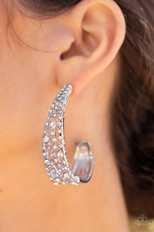 Cold as Ice - White Rhinestone and Silver - Hoop Earrings - Paparazzi Accessories - Classic white rhinestones dot a silvery backdrop of dainty white rhinestones that delicately curves into a solid silver J-hoop, resulting in a jaw-dropping dazzle. Earring attaches to a standard post fitting. Hoop measures approximately 1 1/2" in diameter. Sold as one pair of hoop earrings.