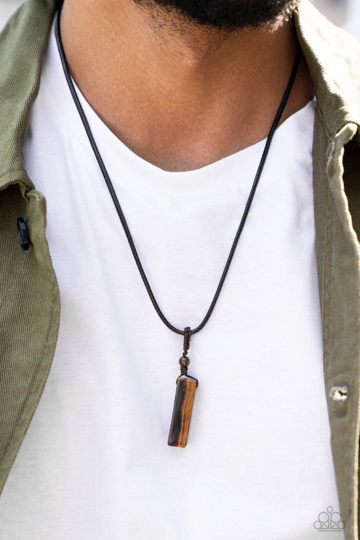 Comes Back ZEN-fold - Brown Necklace - Paparazzi Accessories - A rectangular tiger's eye stone pendulum is knotted in place below a dainty tiger's eye stone bead that glides along a shiny brown cord below the collar, resulting in an earthy pendant. Features an adjustable sliding knot closure necklace.