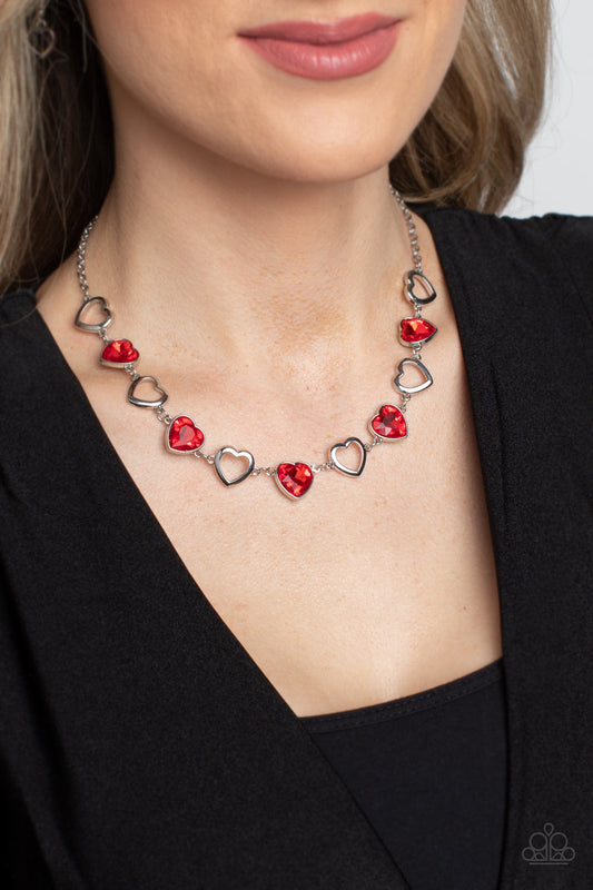 Contemporary Cupid - Red Heart Necklace - Paparazzi Accessories - Shiny, silver silhouette hearts alternate between faceted red heart gems pressed into silver frames.The high-sheen and sparkly display coalesce around the collar for a cupid-like charm.