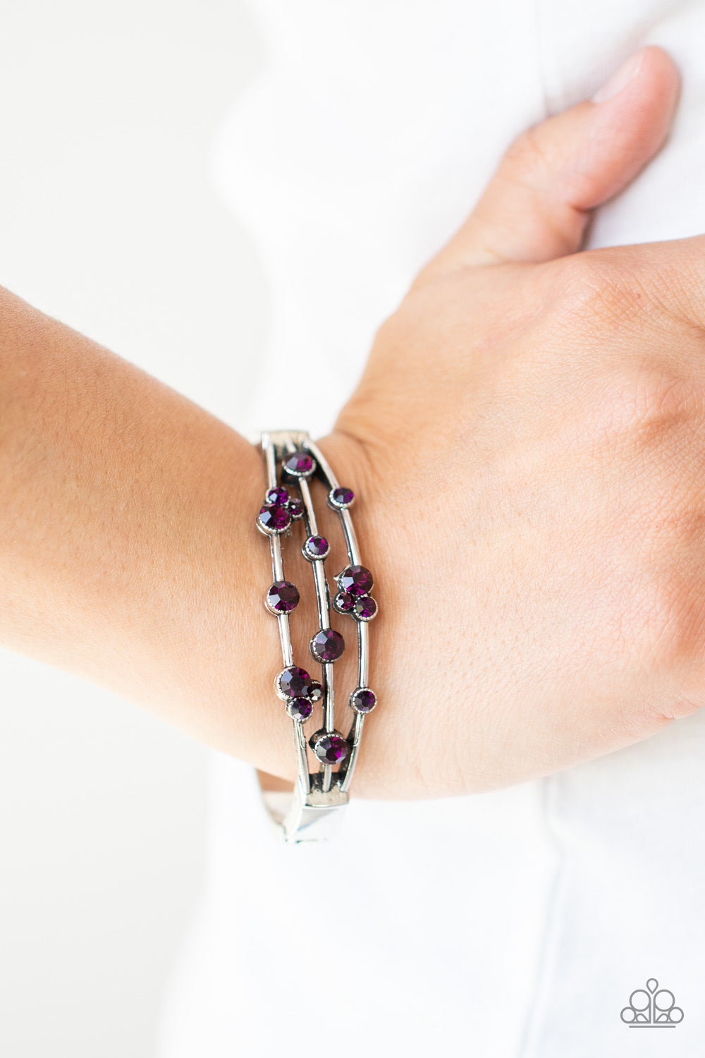 Cosmic Candescence - Purple and Silver Hinge Closure Bracelet - Paparazzi Accessories - 
A smattering of glittery purple rhinestones adorn three silver bars that coalesce into a versatile silver cuff-like bangle around the wrist. Features a hinged closure. Sold as one individual bracelet.
