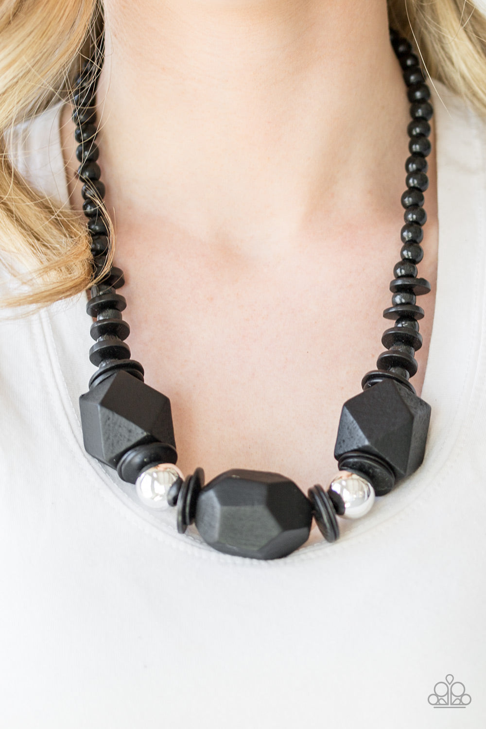 Costa Maya Majesty - Black Wood Necklace - Paparazzi Accessories - Featuring abstract geometric finishes, mismatched black wooden beads are threaded along shiny black cording. Dramatic silver beads are sprinkled between the earthy beading, creating a bold seasonal look below the collar. Features a button loop closure necklace.  Bejeweled Accessories By Kristie - Trendy fashion jewelry for everyone -