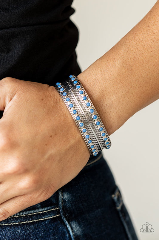 ​Costa Rica Retreat - Blue - Silver Cuff Bracelet - Paparazzi Accessories - Etched and embossed in stacks of linear texture, an antiqued silver cuff is bordered in rows of faceted Spring Lake beads for a refreshing finish. Sold as one individual fashion bracelet. 