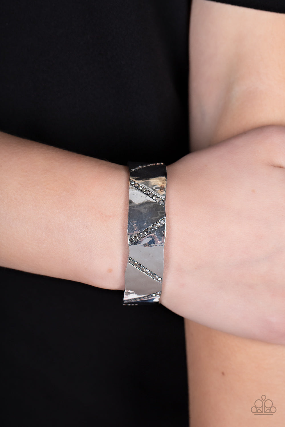 Couture Crusher - Silver Cuff Bracelet - Paparazzi Accessories - Rows of smoky hematite rhinestones slant across the front of a gently hammered silver cuff that waves around the wrist, result in an edgy shimmer. Sold as one individual bracelet.