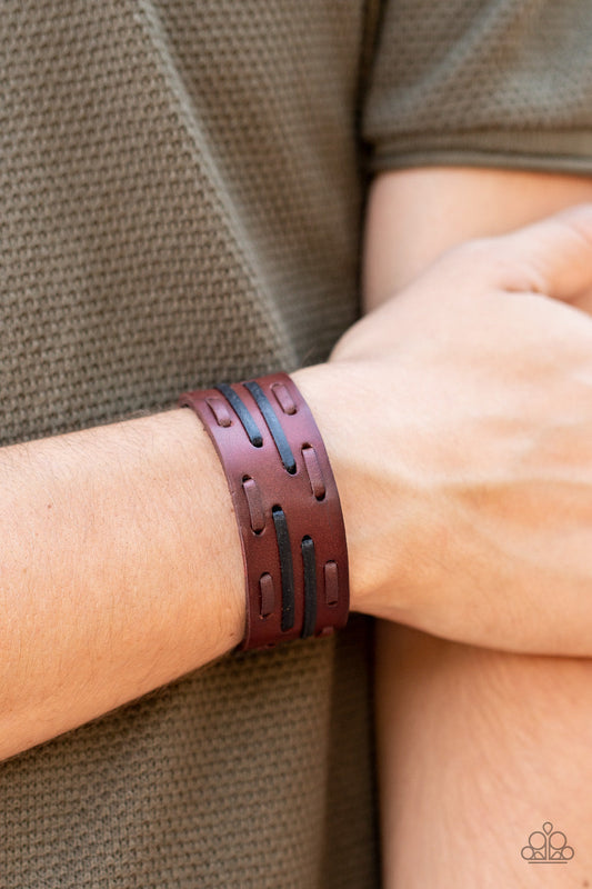 Cowboy Boot Camp - Brown Leather Men's Bracelet - Paparazzi Accessories - Brown and black leather laces are haphazardly threaded through a thick brown leather band, creating a rustic display around the wrist. Features an adjustable snap closure.