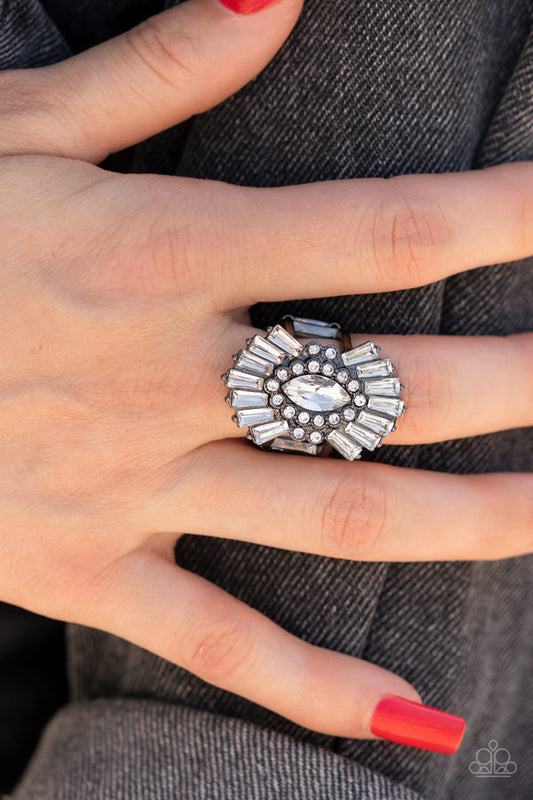 Daringly Deco - Black Ring - Paparazzi Accessories - A white, marquise-cut rhinestone is bordered in glassy white rhinestones atop fans of trapezoidal-cut white rhinestones, resulting in an edgy sparkle that explodes atop the finger. Features a stretchy band for a flexible fit.