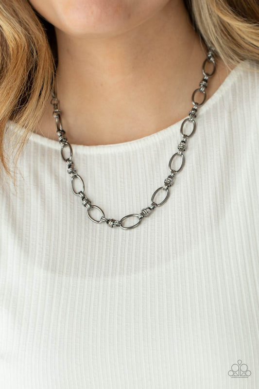 Defined Drama - Black Link - Gunmetal Fashion Necklace  - Paparazzi Accessories - Gunmetal links connect a collection of gunmetal oval frames below the collar, creating an edgy chain. Necklace has an adjustable clasp closure.