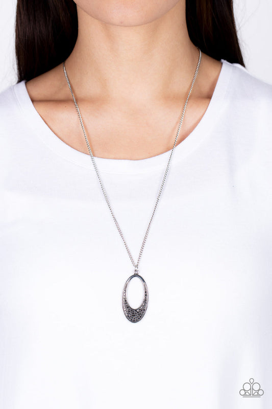 Dip It Into Dazzle - Silver Necklace - Paparazzi Accessories - Encrusted with smoky hematite rhinestones, a simple oval frame featuring an airy oval cutout creates a stylishly modern pendant at the end of a lengthened silver chain. Features an adjustable clasp closure. Sold as one individual necklace.