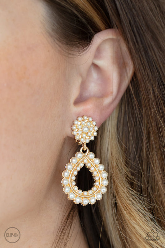 Discerning Droplets - Gold and White Pearlsm - Clip On Earrings - Paparazzi Accessories - Droplets of pearls dot the surface of a gold teardrop frame that suspends from a round pearl encrusted disc for a classic finish. Earring attaches to a standard clip-on fitting. Sold as one pair of clip-on earrings. 
