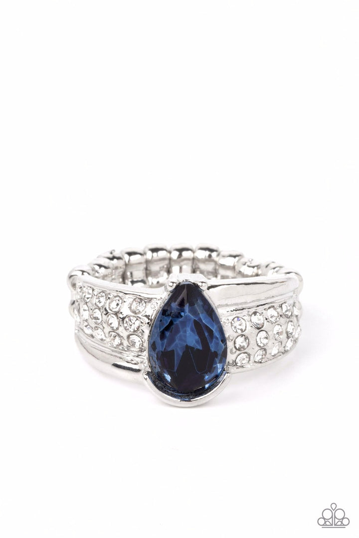 Dive into Oblivion - Blue and Silver Ring - Paparazzi Accessories - Swathed in rows of dainty white rhinestones, an asymmetrical silver band is adorned with a bedazzling Skydiver teardrop rhinestone for a regal finish. Features a dainty stretchy band for a flexible fit.