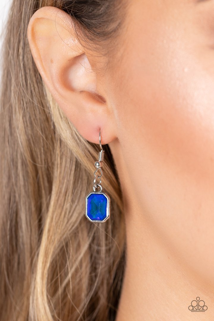 Divine IRIDESCENCE - Blue - Silver Necklace and Earrings - Paparazzi Accessories - 
Featuring a subtle UV shimmer, an oversized collection of radiant cut blue gems delicately link at the bottom of two curved silver rods. Attached to shiny silver chains, the glamorously glitzy display sparkles below the collar for a jaw-dropping finish. Features an adjustable clasp closure.
Sold as one individual necklace. Includes one pair of matching earrings.

