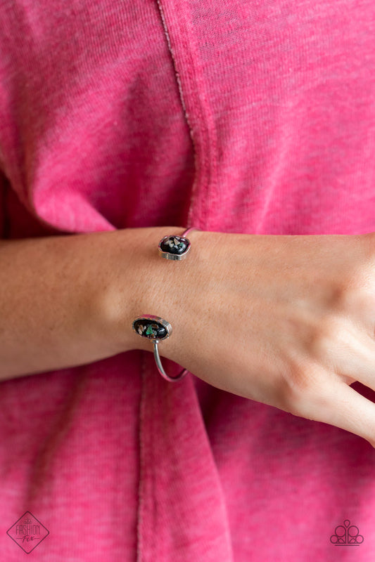 Dont BEAD Jealous - Black and Silver Cuff Bracelet - Paparazzi Accessories - Iridescent shell-like pieces are encased inside two mismatched glassy black beads at both ends of a dainty silver open-faced cuff. The shimmery beads are encased in imperfectly hammered silver frames, adding a whimsy finish fashion bracelet.