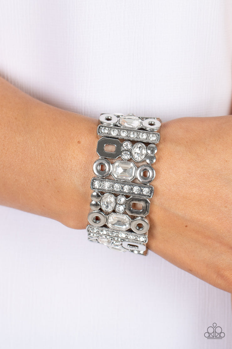 Dynamically Diverse - White and Silver Stretchy Bracelet - Paparazzi Accessories - Geometric silver accents, a mismatched assortment of oval, round, and emerald style white rhinestones coalesce into edgy frames along a stretchy band for an intense sparkle around the wrist.