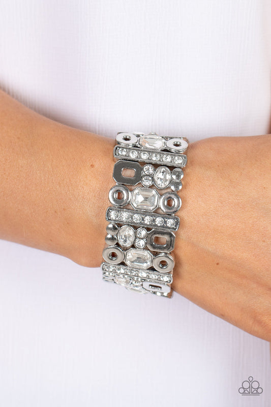 Dynamically Diverse - White and Silver Stretchy Bracelet - Paparazzi Accessories - Geometric silver accents, a mismatched assortment of oval, round, and emerald style white rhinestones coalesce into edgy frames along a stretchy band for an intense sparkle around the wrist.