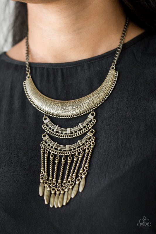Eastern Empress - Brass Necklace - Paparazzi Accessories - Stamped and embossed in tribal inspired patterns, three brass plates connect down the chest, creating a fiercely stacked pendant. Attached to twisted brass rods, ornate brass beads swing from the bottom of the lowermost plate, creating an eye-catching fringe.