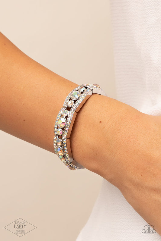 Easy On The Ice - Multi Iridescent Bracelet - Paparazzi Accessories - Iridescent rhinestone encrusted silver bars flank a dazzling trio of oversized iridescent rhinestones, coalescing into a glittery frame. The sparkly frames are threaded along stretchy bands around the wrist, creating an irresistible shimmer. Sold as one individual bracelet.
