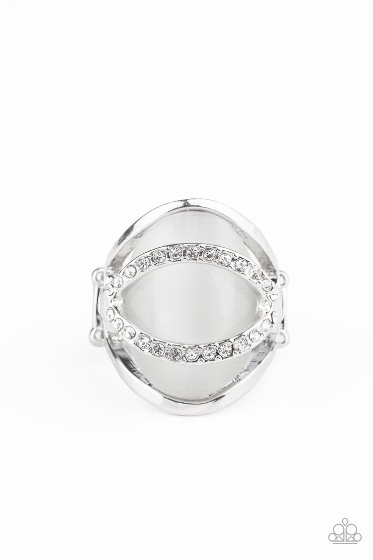 Endless Enchantment - White and Silver Ring - Paparazzi Accessories - 
A pair of glassy white rhinestone encrusted silver bars arc over the top of a glowing white cat's eye stone that is enchantingly nestled in the center of an airy silver frame. Features a stretchy band for a flexible fit.
Sold as one individual ring.
