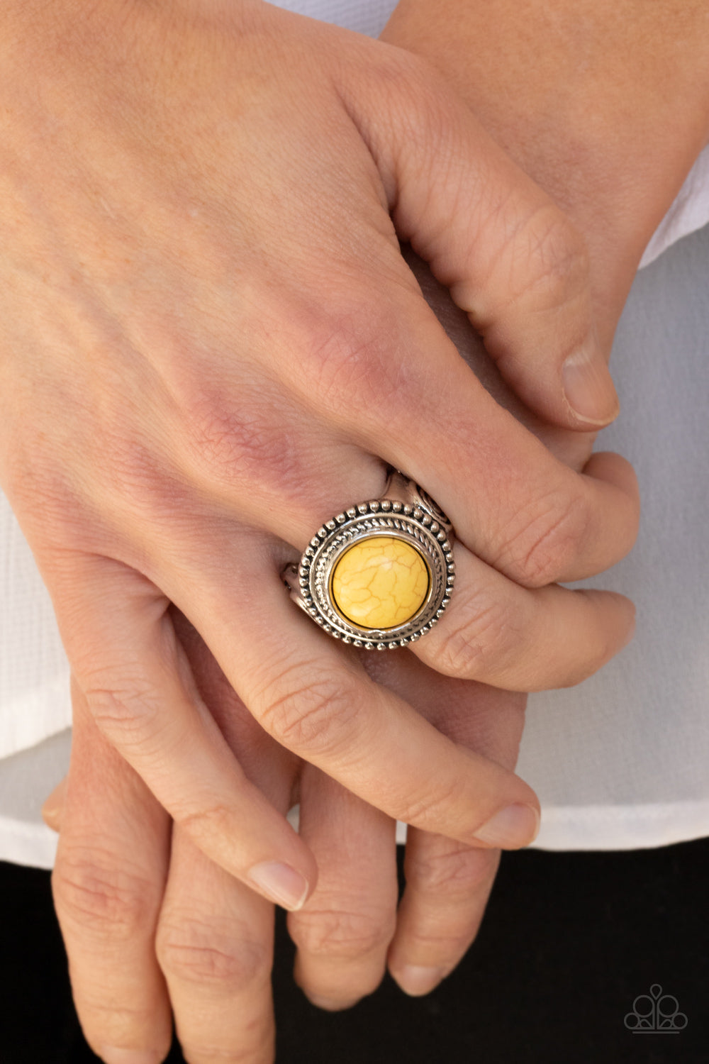 Evolutionary Essence - Yellow and Silver Ring - Paparazzi Accessories -
A round yellow stone is pressed into the center of a studded silver frame embossed with rustic swirls, creating a trendy tribal inspired centerpiece atop the finger. Features a stretchy band for a flexible fit. Sold as one individual ring.
