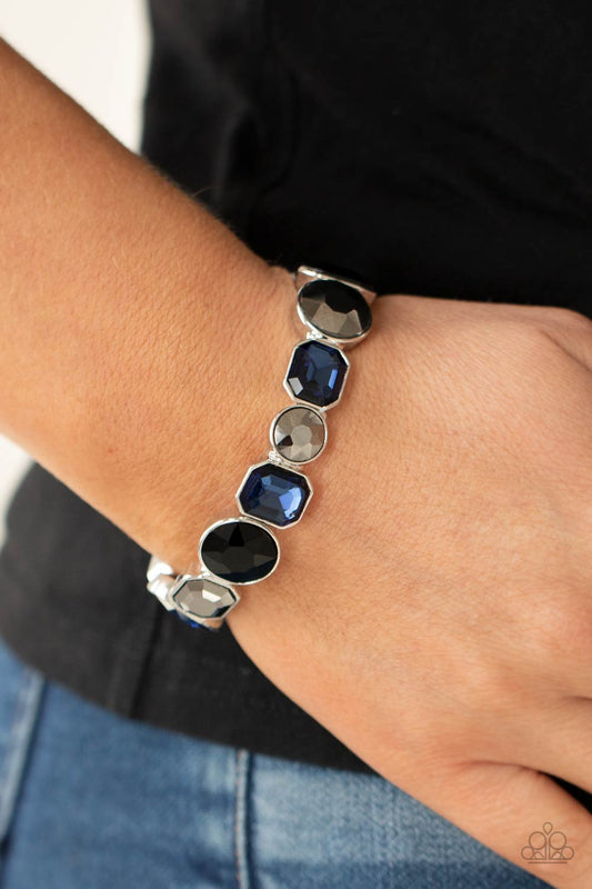 ​Extra Exposure - Black - Blue - Hematite Bracelet - Paparazzi Accessories - 
Encased in sleek silver frames, a smoldering collection of round and emerald cut black, blue, and hematite rhinestones glide along stretchy bands around the wrist, creating a sparkly industrial statement piece. Sold as one individual bracelet.
