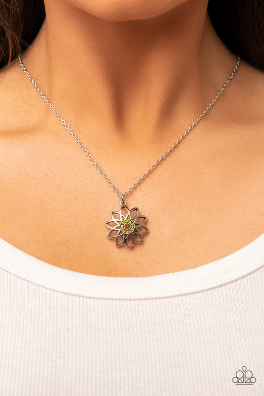 Farmstead Fairytale - Green and Silver Necklace - Paparazzi Accessories - Beveled silver frames fan out from a dainty ring of glittery green rhinestones, blooming into an airy floral pendant at the bottom of a dainty silver chain.