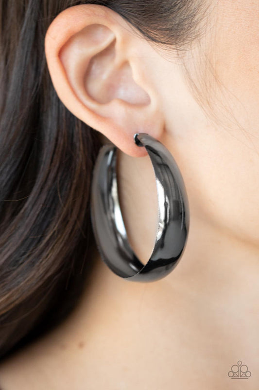 Flat Out Flawless - Black Metal Hoop Earrings - Paparazzi Accessories - An oversized flat gunmetal hoop curls around the ear for a fabulously flawless fashion. Earring attaches to a standard post fitting. Hoop measures approximately 2" in diameter. Sold as one pair of hoop earrings.