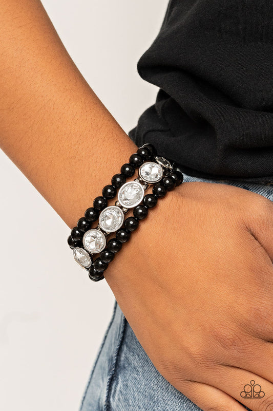 Flawlessly Flattering - Black and White Bracelets - Paparazzi Accessories - Infused with a pair of stretchy black beaded bracelets, a strand of oversized oval white gems are threaded along stretchy bands around the wrist for a flawlessly fabulous finish. Sold as one set of three bracelets.